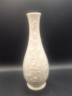 a white vase sitting on top of a table