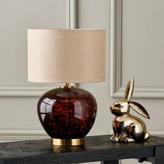 a table with a lamp and a rabbit figurine on it