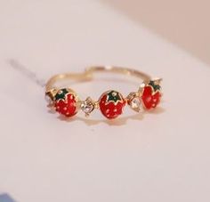 a gold ring with three strawberrys on it