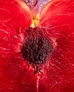 the inside of a red apple with water droplets on it's petals and core