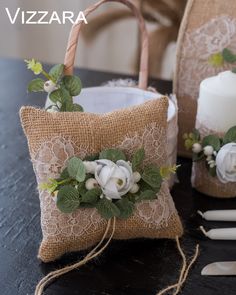 two burlap bags with white flowers and greenery are sitting on a table