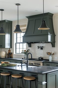 a kitchen with green cabinets and stools next to an island in front of a window