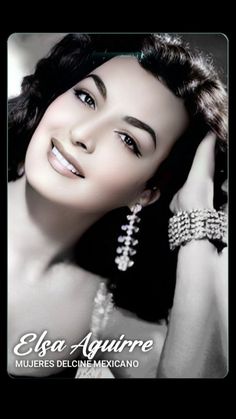 a woman with long black hair wearing pearls and bracelets, posing for the camera