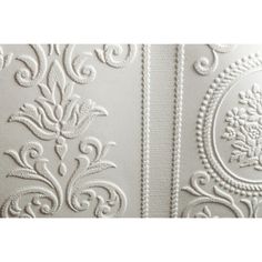 the white wallpaper is decorated with intricate designs