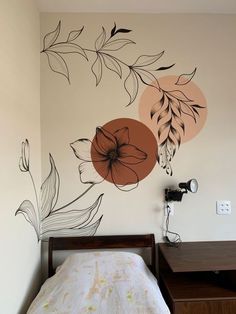 a bed sitting under a painting on the wall next to a night stand and desk