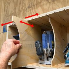 a man is working with tools in his workbench and holding the door open