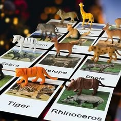 there are many different types of animals on this card game board, including tigers, rhinoceros, zebras and giraffes