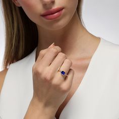 This ageless design inspired by the Art Deco era showcases a striking and brilliant emerald cut sapphire that rests within a smooth bezel setting. Twinkling diamonds cascade downwards along the shank, adding a touch of sparkle that shimmers with each movement. We love this classic yet modern style worn solo for a lasting impact. Metal: 18kt Gold Sapphire Weight: 1.50 ct. Diamond Weight: 0.08 ct. Measurements: 7.0 mm length *Please note that the listed ct. weights are approximate and may be subje Modern Sapphire Ring With Prong Setting, Luxury Square Cut Sapphire Ring, Timeless Emerald Cut Sapphire Ring With Center Stone, Elegant Asscher Cut Birthstone Ring, Timeless Sapphire Diamond Ring With Emerald Cut, Timeless Emerald-cut Sapphire Ring With Bezel Setting, Timeless Sapphire Jewelry With Radiant Cut, Timeless Emerald Cut Sapphire Ring, Timeless Emerald-cut Sapphire Ring