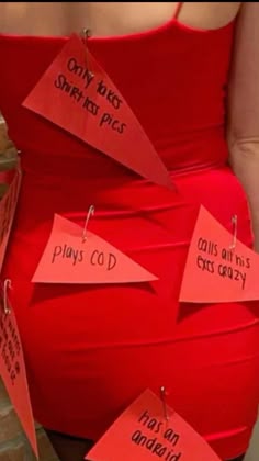 a woman in a red dress with notes attached to her waist