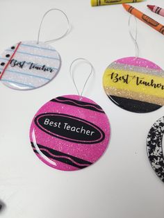 three teacher's ornament hanging on a table with crayons and markers