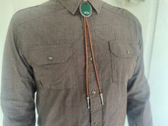 This awesome bolo tie has a southwestern design and green agate centerpiece. The cord is genuine leather. All the stones will vary slightly. Our bolos pair nicely with many of our belt buckles! They make wonderful gifts. The western bolo tie rope length is 39'' ; charm agate stone pendant size is 2'' x 1 1 /2'' Western Brown Bolo Ties For Western-themed Events, Vintage Brown Bolo Tie With Concho, Adjustable Southwestern Bolo Tie, Brown Concho Bolo Tie Lariat, Brown Concho Bolo Ties Lariat, Brown Concho Bolo Tie, Brown Bolo Ties As A Gift, Brown Bolo Tie For Gift, Western Brown Bolo Ties With Concho