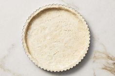 an uncooked pie crust on a marble surface