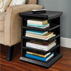 a black end table with books on it and a chair in the background for $ 19 99