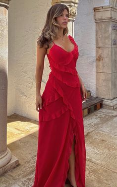 a woman in a red dress posing for the camera