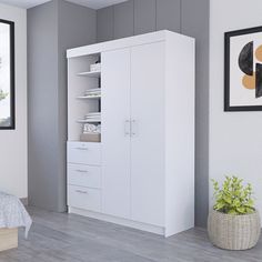 a bedroom with a bed and white cupboards in the corner next to a window