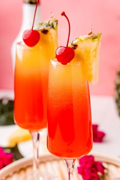 two glasses filled with drinks sitting on top of a table