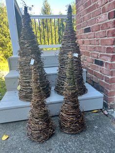 three small trees made out of twigs on the porch