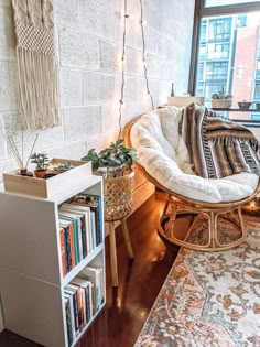 a living room filled with furniture and a book shelf next to a window covered in christmas lights