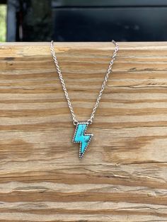 Looking to add a pop of turquoise to your jewelry collection? This Lightning Bolt Stone Necklace can add a bit of flash to any western inspired outfit! It features a silver chain with a turquoise stone bordered with a silver accent. Light up any look with this bolt of color. Faux silver and turquoise Cheap Turquoise Necklace, Cheap Turquoise Summer Jewelry, Cheap Turquoise Necklaces For Festivals, Cheap Turquoise Necklace For Festivals, Lightning Jewelry, Punchy Jewelry, Lightning Bolt Jewelry, Western Jewelry Necklace, Western Jewerly