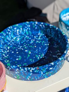 two blue plates sitting on top of a table next to other bowls and containers filled with confetti