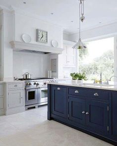 a large kitchen with blue cabinets and white counter tops, an island in the middle