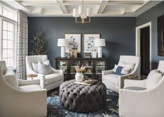 a living room with blue walls and white furniture