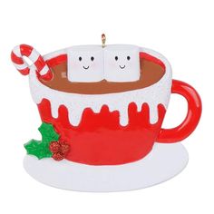 a christmas ornament with two hot chocolates in a cup and candy cane