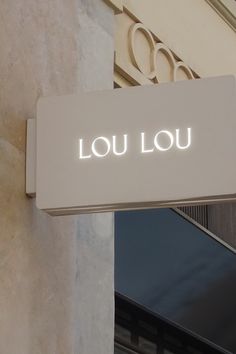 a sign that reads lou lou hanging from the side of a building