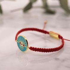 Exquisite Evil Eye Bracelet in Gold: A Symbol of Luxury and Guardian Charm Step into the world of Atelier Petites Pierres, where each piece is a story of elegance and protection. Introducing the Macrame Sliding Knot Bracelet with Enamel Evil Eye - an embodiment of craftsmanship that blends luxury with tradition. This isn't just an accessory; it's an evil eye protection bracelet that carries profound meanings, encapsulated in every detail. Crafted for Distinction and Luck Our evil eye bracelet in gold is more than an ornament; it's a beacon of good fortune. With the 24k gold-filled brass shimmering with the allure of pure gold, and the iconic enamel evil eye, this bracelet is a treasure trove of luck wrapped around your wrist. Whether you choose the fiery spirit of the red evil eye bracelet Resizable Spiritual Bracelets, Symbolic Adjustable Round Bracelets, Handmade Adjustable Spiritual Gold Bracelet, Adjustable Spiritual Gold Jubilee Bracelet, Adjustable Spiritual Chain Bracelet, Spiritual Adjustable Chain Bracelet, Round Wristband With Bracelet Strap As Gift, Adjustable Round Chain Bracelet With Evil Eye, Handmade Adjustable Gold Bracelet