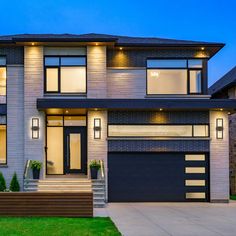 a two story house at night with lights on the windows and steps leading up to the front door