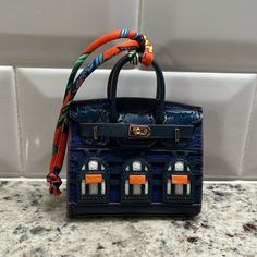 Beautiful Navy Blue And Orange Leather Bag Charm Intricate Details Goldtone Hardware 4 Feet Fabric Hanger Comes In A Dust Bag, In A Box With Tissue Comes From A Smoke Free Home Absolutely Stunning Piece! Luxury Blue Rectangular Case Shoulder Bag, Luxury Blue Rectangular Shoulder Bag, Designer Blue Tote Box Bag, Designer Blue Box Bag For Travel, Designer Blue Rectangular Case Bag, Designer Blue Box Bag With Detachable Handle, Designer Blue Box Bag With Top Handle, Designer Blue Top Handle Box Bag, Luxury Blue Square Box Bag