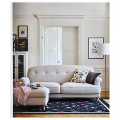 a living room with a white couch and blue rug