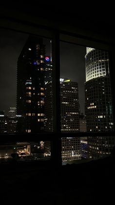 the city skyline is lit up at night with skyscrapers in the foreground and lights on