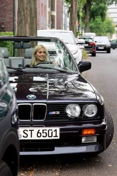 a woman sitting in the driver's seat of a bmw