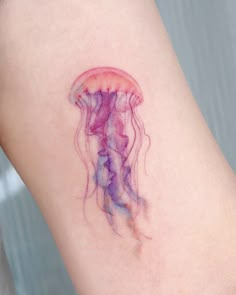 a small jellyfish tattoo on the arm