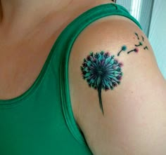 a woman with a tattoo on her arm has a dandelion design on it