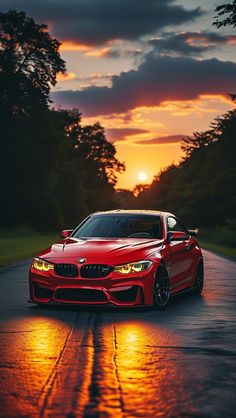 a red sports car parked on the side of a road at sunset with trees in the background