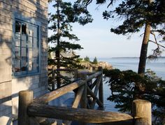 a wooden bench sitting on the side of a building next to a body of water