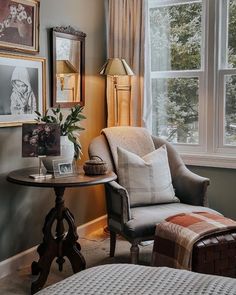 a living room filled with furniture and pictures on the wall next to a window covered in curtains