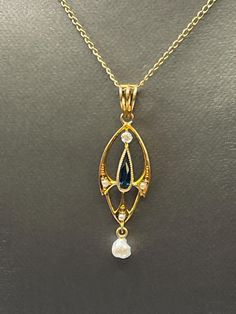 A gorgeous ladies antique pendant beautifully crafted in 14 karat solid yellow gold.  This amazing antique is set with a teardrop Sapphire in the center with a freshwater pearl that suspends gracefully at the bottom.  One round white minor cut diamond and three cultured pearls also accent this unique piece.  A triple loop bale secures this beauty to your favorite chain.  Looks fabulous on! Weight: 1.2 grams  Length:  1 ½" Width:  ⅜" Our Price $375.00  Regularly Priced At $550.00 Please See Our Video Remember - If you're purchasing for yourself or a gift for a loved one, buy with confidence.  We Guarantee Everything We Sell!  SKU # P644 Formal Yellow Gold Drop Necklace With Pearl Pendant, Antique Yellow Gold Teardrop Necklaces, Ornate Yellow Gold Jewelry With Pearl Pendant, Antique Yellow Gold Teardrop Necklace, Antique Teardrop Yellow Gold Necklaces, Victorian Gold Pearl Necklace With Pearl Drop, Antique Gold Pear-shaped Jewelry, Victorian Pearl Drop Necklace As Gift, Anniversary Teardrop Pearl Pendant Drop Necklace