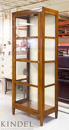 a tall wooden display case with glass doors