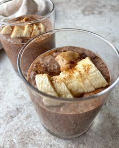 two glasses filled with chocolate pudding and banana slices