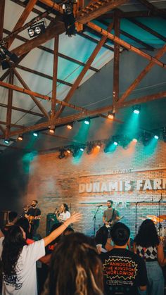 a group of people that are standing in front of a brick wall and some lights