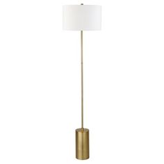 a gold floor lamp with a white shade