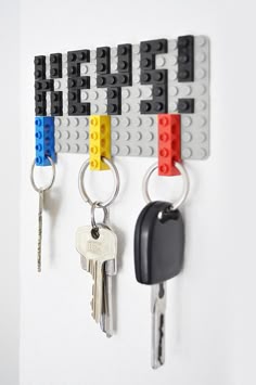 some lego key chains are hanging on the wall with keys attached to them and one is missing