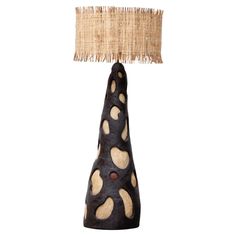 a black and brown table lamp with a burlap shade on it's side