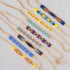 six wooden knitting needles with colorful beading on them, lined up against a white background