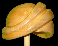 a yellow lollipop on a wooden stick against a black background with clippings