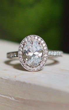 a white diamond ring sitting on top of a wooden table