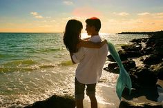 a man and woman embracing on the beach